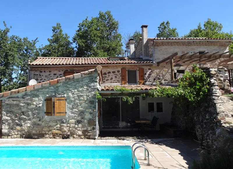 Extérieur du gîte La Bergerie au Vallon des Étoiles en Ardèche, maison authentique en pierre avec piscine privée et terrasse plein sud